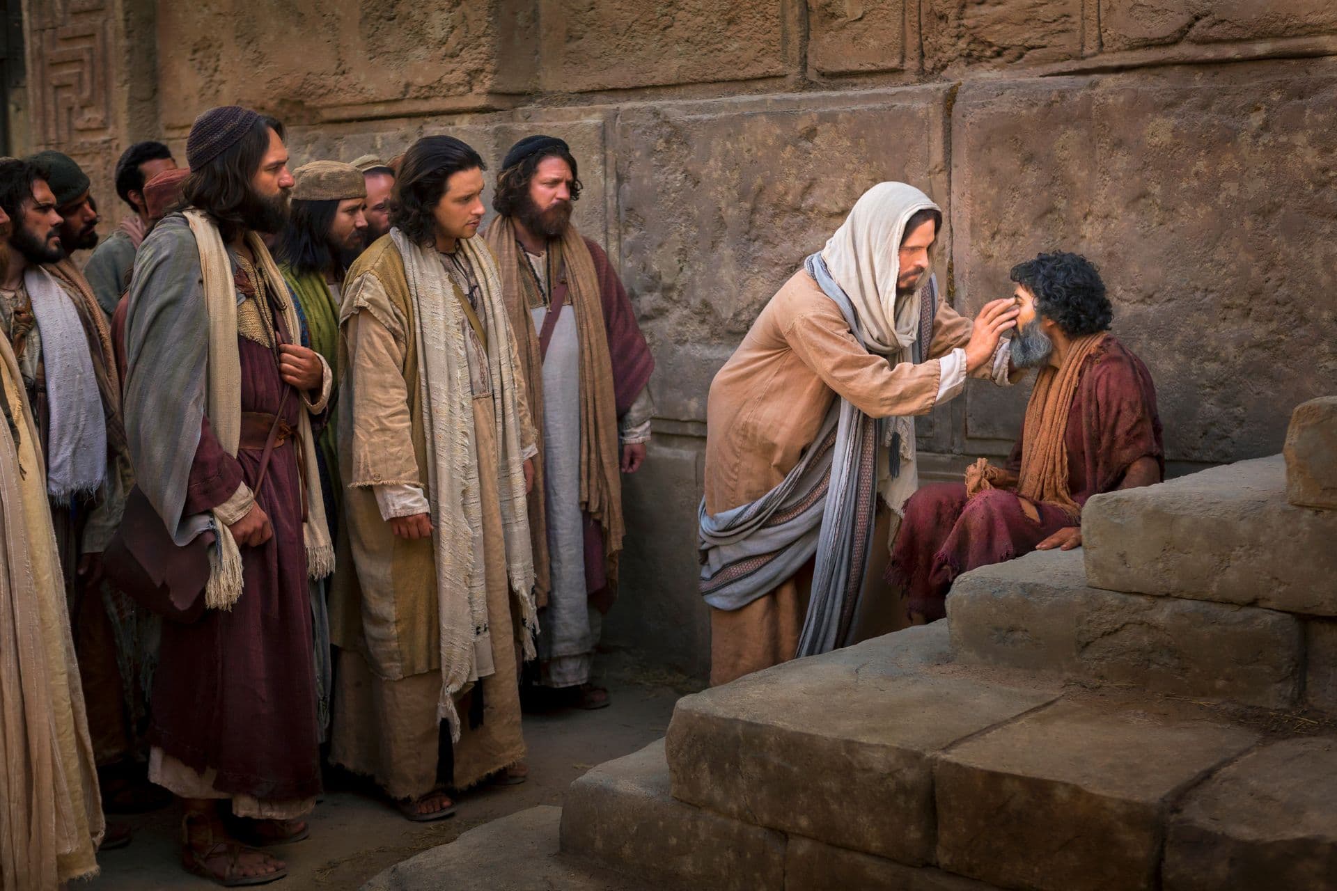 Jesus Christ bending to touch the eyes of a seated man while his disciples look on beside a stone wall.